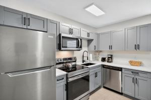 圣徒皮特海滩Park Shore Suites Unit 4的配有白色橱柜和不锈钢冰箱的厨房