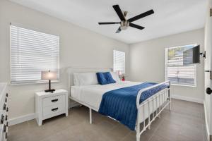 圣徒皮特海滩Park Shore Suites Unit 4的一间卧室，里面有一张床和一个吊扇