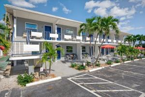an apartment building with palm trees and a parking lot at Sunset Beach Suites Unit 9 in St Pete Beach