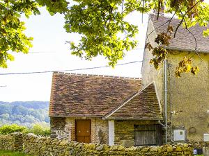 a stone house with a stone wall next to a building at Grande Maison avec terrasse et proche rivière en Berry - FR-1-591-13 in Badecon-le-Pin