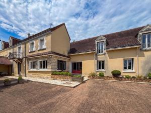 une maison avec une allée en briques devant elle dans l'établissement Maison de vacances avec grande piscine et tennis, proche du Zoo de Beauval et des Châteaux de la Loire - FR-1-591-47, à Villentrois
