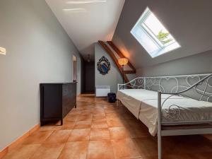 une chambre avec un lit et une lucarne dans l'établissement Maison de vacances avec grande piscine et tennis, proche du Zoo de Beauval et des Châteaux de la Loire - FR-1-591-47, à Villentrois 26 autres photos