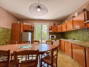 une cuisine avec une grande table et des chaises en bois dans l'établissement Maison de vacances avec grande piscine et tennis, proche du Zoo de Beauval et des Châteaux de la Loire - FR-1-591-47, à Villentrois