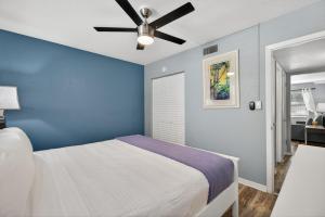 una camera blu con letto e ventilatore a soffitto di Sunset Beach Suites Unit 8 a St Pete Beach
