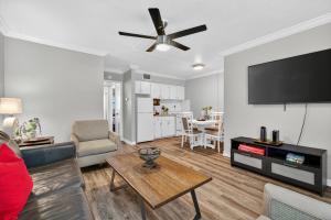 a living room with a couch and a flat screen tv at Sunset Beach Suites Unit 7 in St. Pete Beach