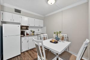 a kitchen with a table and a white refrigerator at Sunset Beach Suites Unit 7 in St. Pete Beach
