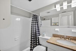 a bathroom with a sink and a toilet and a mirror at Sunset Beach Suites Unit 7 in St. Pete Beach +36 photos
