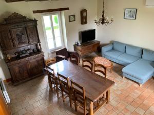 ein Wohnzimmer mit einer Couch und einem Tisch und Stühlen in der Unterkunft Charmant Gîte Familial avec Grand Terrain, à Proximité de Fontgombault et de la Creuse - FR-1-591-118 in Sauzelles