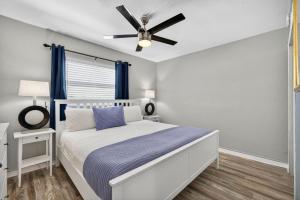 a bedroom with a bed with a ceiling fan at Sunset Beach Suites Unit 6 in St. Pete Beach