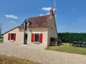 a small house with red shutters and chairs at Maison de charme en Berry - proche Zoo de Beauval et Cité médiévale de Loches - FR-1-591-169 in Arpheuilles
