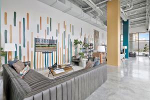 una sala de estar con un sofá y una pared grande en Chic Studio, Gym Access, Steps to Regions Field) for field, en Birmingham