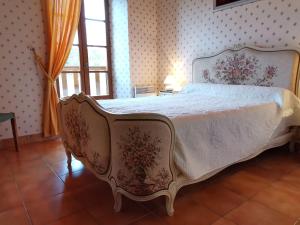 - une chambre avec un grand lit et un couvre-lit blanc dans l'établissement Grande maison en pierres avec jardin, proche d'un bourg médiéval, animaux acceptés - FR-1-582-161, à Allègre