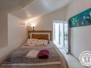 ein Schlafzimmer mit einem Bett in einem Zimmer in der Unterkunft Gîte charmant avec jardin au cœur du vignoble du Layon, proche Saumur, 9 couchages, vélos inclus - FR-1-622-19 in Aubigné
