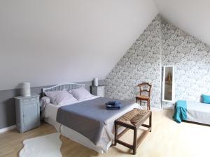 une chambre avec un lit, une chaise et un miroir dans l'établissement Jolie maison en pierre avec jardin privatif, proche de la Loire et des châteaux, animaux bienvenus - FR-1-622-23, à Saint-Sulpice