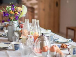 une table avec des bouteilles, des assiettes et des œufs dessus dans l'établissement Longère rénovée avec charme, 5 chambres, grand jardin, proche du village, idéale pour 15 pers. - FR-1-410-355, à Saint-Léonard-des-Bois