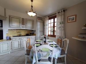 a white kitchen with a table and chairs and a window at Maison familiale au cœur de la Haute-Loire - Randos et découverte du Puy-en-Velay - FR-1-582-322 in Saint-Germain-Laprade