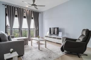 a living room with a couch and chairs and a tv at The One by Nakza Stays, Lakeview Suites at Putrajaya in Putrajaya