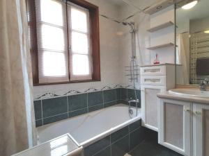 a bathroom with a tub and a sink at Maison familiale au cœur de la Haute-Loire - Randos et découverte du Puy-en-Velay - FR-1-582-322 in Saint-Germain-Laprade