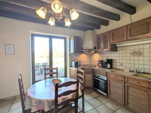 eine Küche mit Tisch und Stühlen und einem Fenster in der Unterkunft Gîte familial près de Châteauroux avec jardin, aire de jeux et location de salle, idéal pour 8 pers. - FR-1-591-12 in Arthon