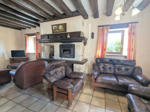 ein Wohnzimmer mit Ledermöbeln und Kamin in der Unterkunft Gîte familial près de Châteauroux avec jardin, aire de jeux et location de salle, idéal pour 8 pers. - FR-1-591-12 in Arthon