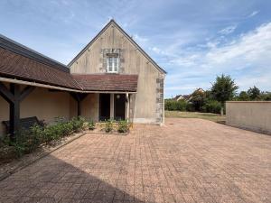 une grange avec une allée en briques devant un bâtiment dans l'établissement Maison de Charme avec Piscine Chauffée et Tennis à Proximité du Zoo de Beauval - FR-1-591-26, à Villentrois