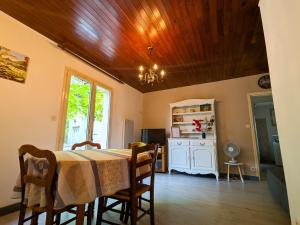 a dining room with a table and a kitchen at Maison de vacances en Berry avec jardin clos, proche plage et sentiers, animaux acceptés - FR-1-591-319 in Baraize
