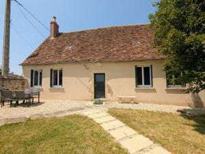 une maison avec une table et des chaises devant dans l'établissement Charmante maison avec jardin, proche de George Sand, circuit auto, hippodrome, plans d'eau et nature. - FR-1-591-320, à Thevet-Saint-Julien