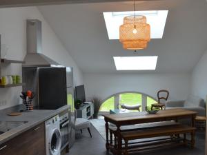 a kitchen with a table and a dining room at Gîte rénové, 35 min de Nancy, près de châteaux, fibre, parking privé, idéal famille - FR-1-584-169 in Vroncourt