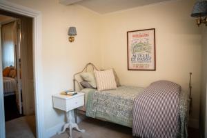 ein kleines Schlafzimmer mit einem Bett und einem Nachttisch in der Unterkunft Stunning Apartment in Historic Federal Hill Mansion near Downtown & College Hill in Providence