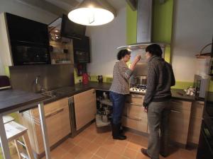 zwei Personen stehen in einer Küche und bereiten Essen zu in der Unterkunft Séjour nature au cœur du Parc de la Brenne: gîte 4 chambres, jardin et terrasse, proche de Rosnay - FR-1-591-141 in Rosnay + 21 Fotos