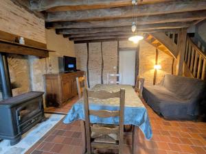 - une salle à manger avec une table et une cuisinière dans l'établissement Maison de Caractère Rénovée avec Jardin, Terrasse, et Proche du Château Guillaume - FR-1-591-131, à Lignac