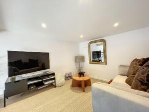 un salon avec un canapé et un miroir dans l'établissement Gîte confortable à Saugues pour randonneurs, 3 chambres spacieuses avec salle d'eau privative - FR-1-582-365, à Cubelles 11 autres photos