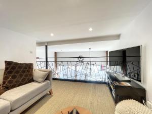 un salon avec un canapé et un balcon dans l'établissement Gîte confortable à Saugues pour randonneurs, 3 chambres spacieuses avec salle d'eau privative - FR-1-582-365, à Cubelles