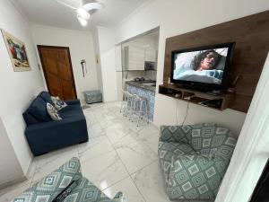 a living room with a television and a couch at Apartamento Praia Grande 300 m da praia in Praia Grande