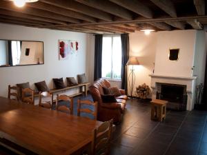 a living room with a table and chairs and a fireplace at Gîte spacieux avec piscine chauffée, wifi et tennis au bord de la Loire - FR-1-590-97 in Sigloy
