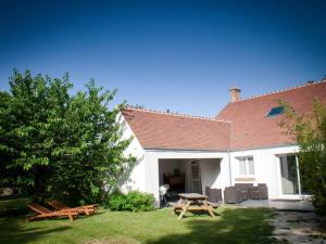 a house with a picnic table and benches in the yard at Gîte spacieux avec piscine chauffée, wifi et tennis au bord de la Loire - FR-1-590-97 in Sigloy