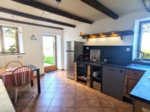 a kitchen with a table and a dining room at Gîte familial calme avec jardin, wifi et équipements bébé, animaux acceptés - FR-1-584-92 in Saint-Germain