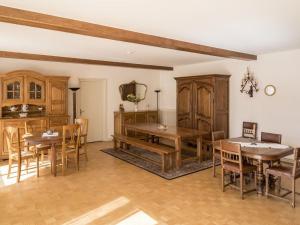 ein Esszimmer mit Holztischen und Stühlen in der Unterkunft Gîte pour 12 face au château de Thillombois avec jardin, cheminée et équipements PMR - FR-1-585-38 in Thillombois