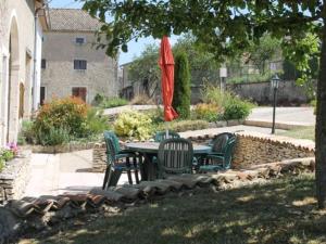 ein Tisch und Stühle unter einem Baum mit einem Sonnenschirm in der Unterkunft Gîte de charme avec cheminée, terrasse et garage à Brixey-aux-Chanoines - FR-1-585-10 in Brixey-aux-Chanoines