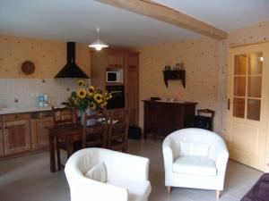 ein Wohnzimmer mit zwei weißen Stühlen und einem Tisch in der Unterkunft Gîte calme près du Lac de Madine, avec jardin privé, cuisine équipée et tout inclus - FR-1-585-64 in Vigneulles-lès-Hattonchâtel