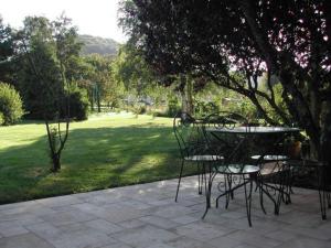 eine Terrasse mit Tisch und Stühlen in einem Park in der Unterkunft Gîte calme près du Lac de Madine, avec jardin privé, cuisine équipée et tout inclus - FR-1-585-64 in Vigneulles-lès-Hattonchâtel