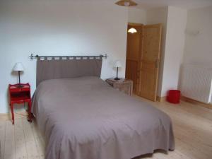 ein Schlafzimmer mit einem großen Bett und einem roten Stuhl in der Unterkunft Gîte calme près du Lac de Madine, avec jardin privé, cuisine équipée et tout inclus - FR-1-585-64 in Vigneulles-lès-Hattonchâtel