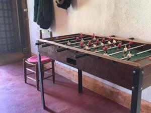 Ein hölzerner Tischkicker steht neben einem Stuhl. in der Unterkunft Maison de famille XVIIIème avec jardin privatif en pleine nature, proche Châteauroux - FR-1-591-207 in Saint-Maur