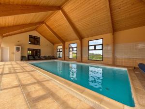 une piscine dans une maison avec un plafond en bois dans l'établissement Villa avec Piscine Intérieure, Billard et Tennis, proche Zoo de Beauval et Châteaux de la Loire - FR-1-591-225, à Villentrois