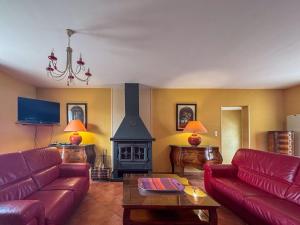 un salon avec un canapé rouge et une cheminée dans l'établissement Villa avec Piscine Intérieure, Billard et Tennis, proche Zoo de Beauval et Châteaux de la Loire - FR-1-591-225, à Villentrois