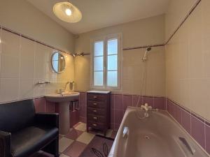 une salle de bains avec baignoire et lavabo dans l'établissement Villa avec Piscine Intérieure, Billard et Tennis, proche Zoo de Beauval et Châteaux de la Loire - FR-1-591-225, à Villentrois 9 autres photos