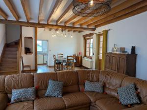 a living room with a brown couch and a table at Charmante Maison pour 6 à St Père-sur-Loire, Vue Loire - FR-1-590-178 in Saint-Père-sur-Loire