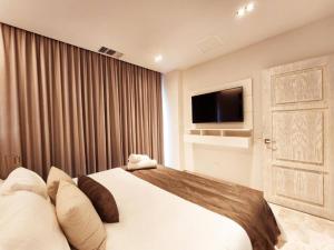 a hotel room with a bed and a television at Luxury 1BR Condo Prime Location in Playa del Carmen +26 photos