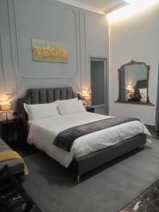 Un dormitorio con una cama grande y un espejo. en Sagittarius B&B, en Cetraro