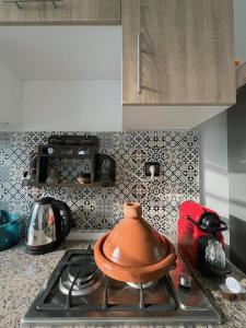 a tea kettle on a stove in a kitchen at Séjour détente près plage des nations in Sale